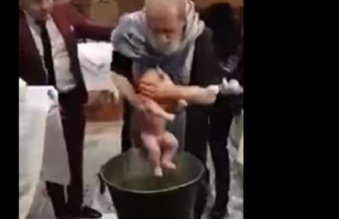 Sveštenik bebi tokom krštenja stavlja ruku preko usta da ne bi plakala (Video)