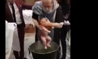 Sveštenik bebi tokom krštenja stavlja ruku preko usta da ne bi plakala (Video)