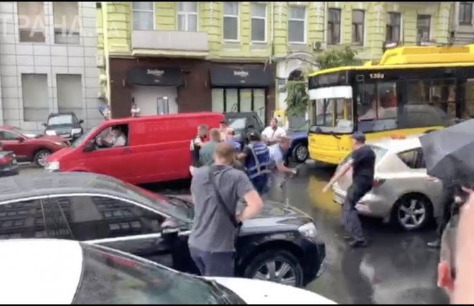 Skočio na Porošenkov automobil, pa dobio udarac kišobranom (VIDEO)